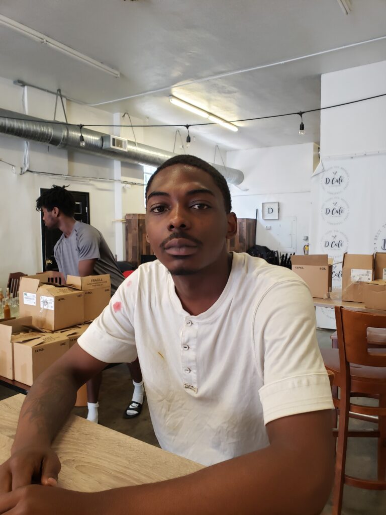 21-yr-old Derriontae Trent, a program participant supervising the production of Sweet Sol, organic sauce at Miss. Dee's Cafe.